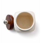 Ceramic container with a wooden lid on a white background