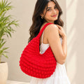 Side profile of the red crochet hobo bag showing capacity and shape