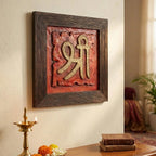 Close-up detail of the metallic gold Shree symbol carved on textured red stone