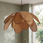 Angle view of natural sugarcane layered petal pendant light unlit near a window