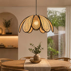 Sugarcane woven petal pendant lamp suspended above a wooden dining table in a boho room