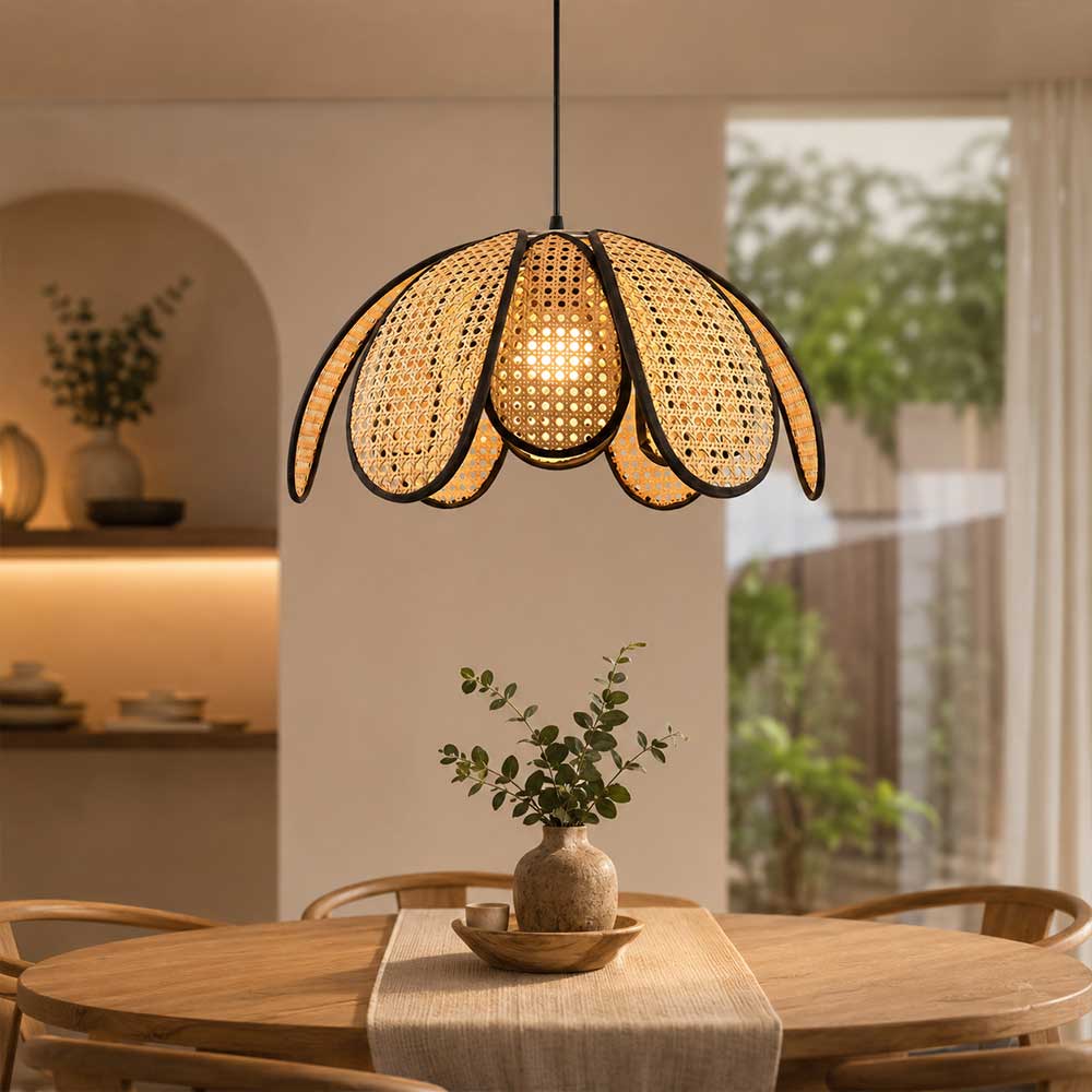 Sugarcane woven petal pendant lamp suspended above a wooden dining table in a boho room