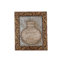 Front view of a handcrafted stone painting featuring an ornamental vase inside an ornate, floral-carved dark wooden frame.