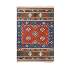 Colorful patterned rug with geometric design on a white background