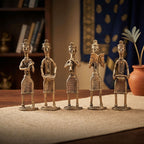 Set of five decorative bronze figures on a textured surface with a blurred background