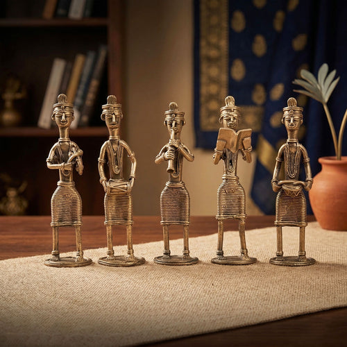 Set of five decorative bronze figures on a textured surface with a blurred background
