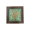 Front view of a handcrafted Vishnu Tilak stone painting with turquoise and gold relief in a wooden frame.