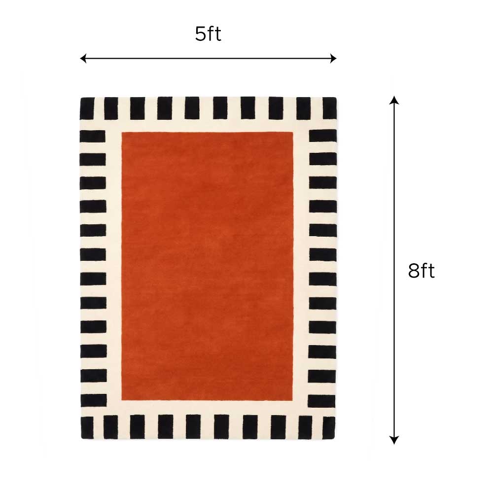 Close-up detail view of the premium wool texture and clean stitching of the burnt orange and striped border rug.
